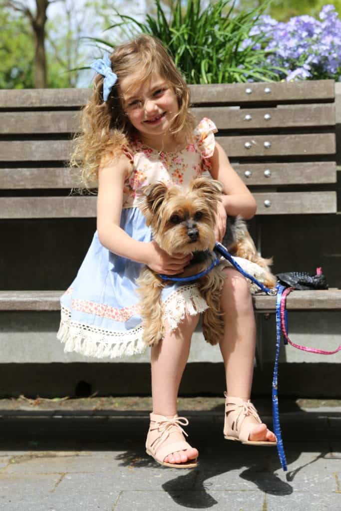 Girl wearing Cheeky Plum dress and holding dog