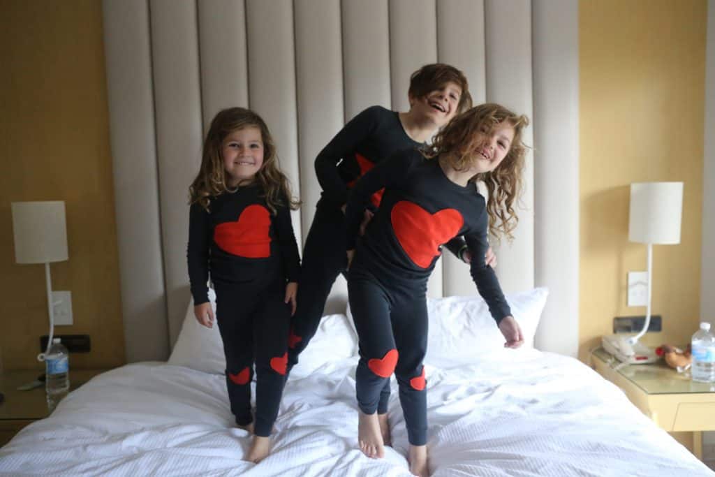 Kids jumping on bed in their pajamas