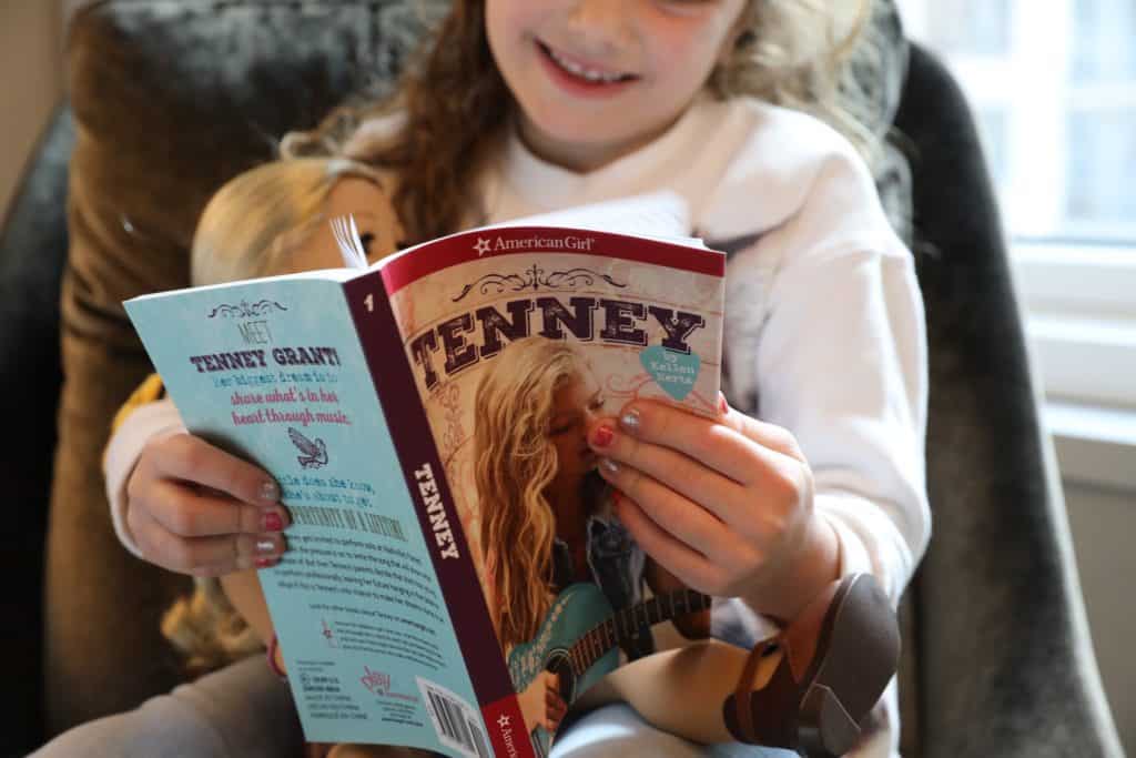 Girl reading Tenney American Girl doll's story