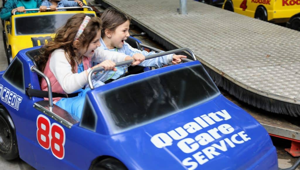 Girls in amusement park race cars