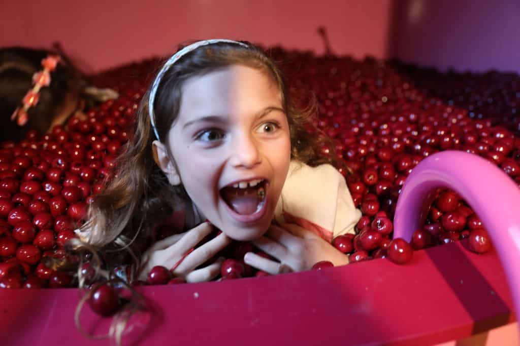 Child playing in a pit of pretend cherries