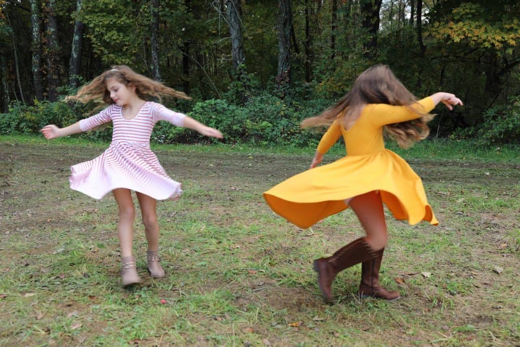 Girls Twirling in circles in Alice and Ames dresses