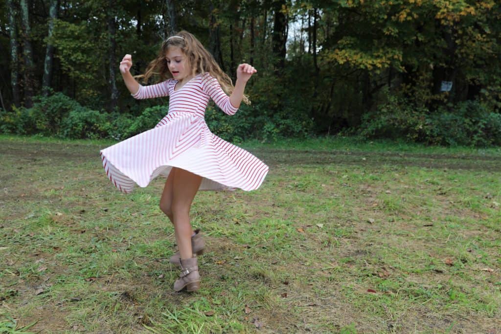 Little girl twirling in dress with circle skirt