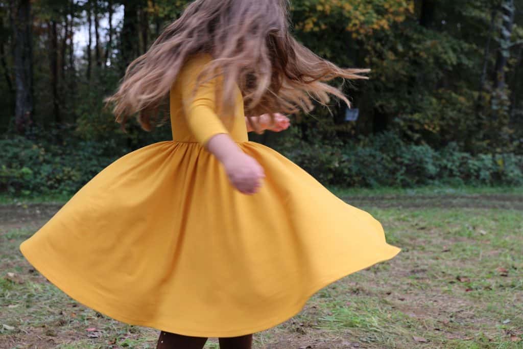Little girl twirling in Alice and Ames dress