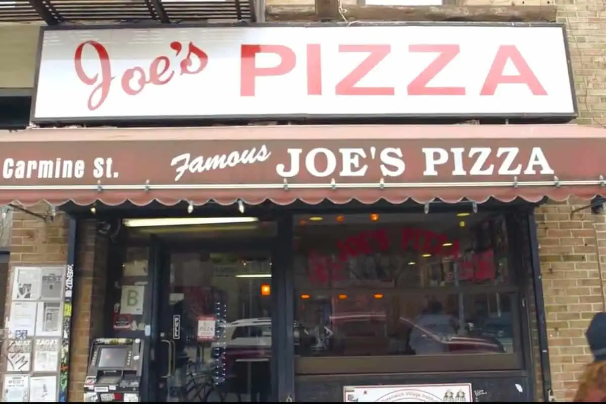 Infamous Joe's Pizza exterior with white sign and red awning 