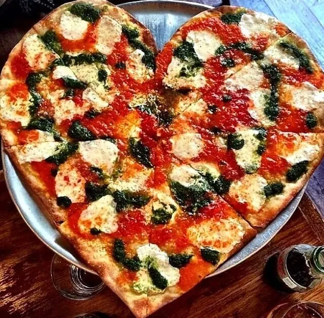Heart-shaped pizza with red sauce, mozzarella, and pesto at Rubirosa 