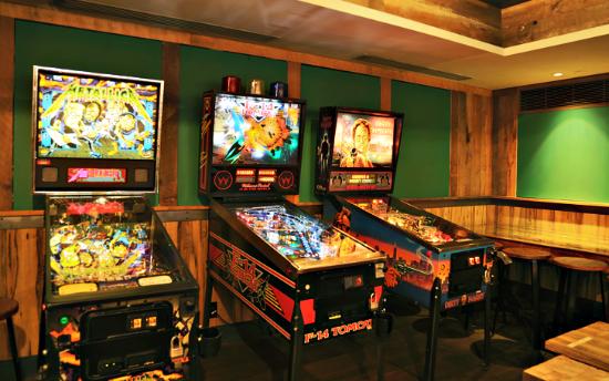 Game room with vintage pinball machines in NYC restaurant Treadwell Park
