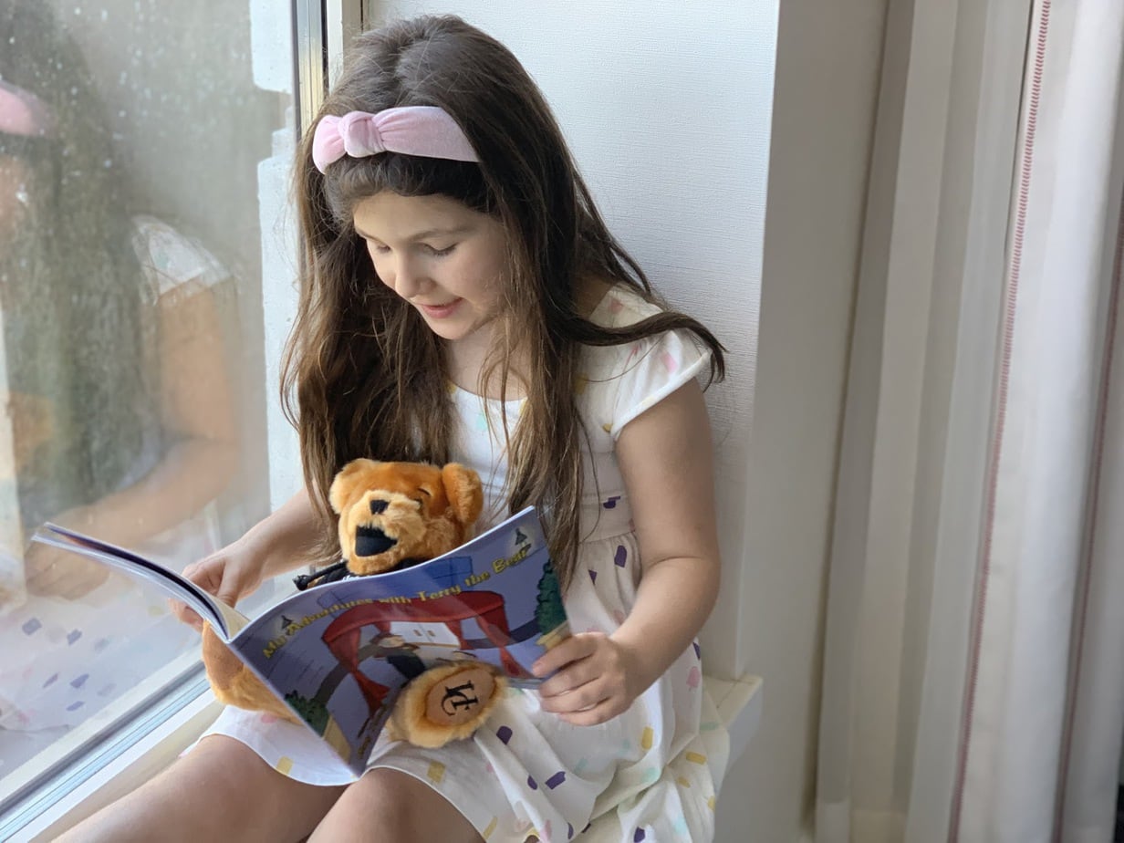 Child reading book to stuffed animal at Hotel Commonwealth