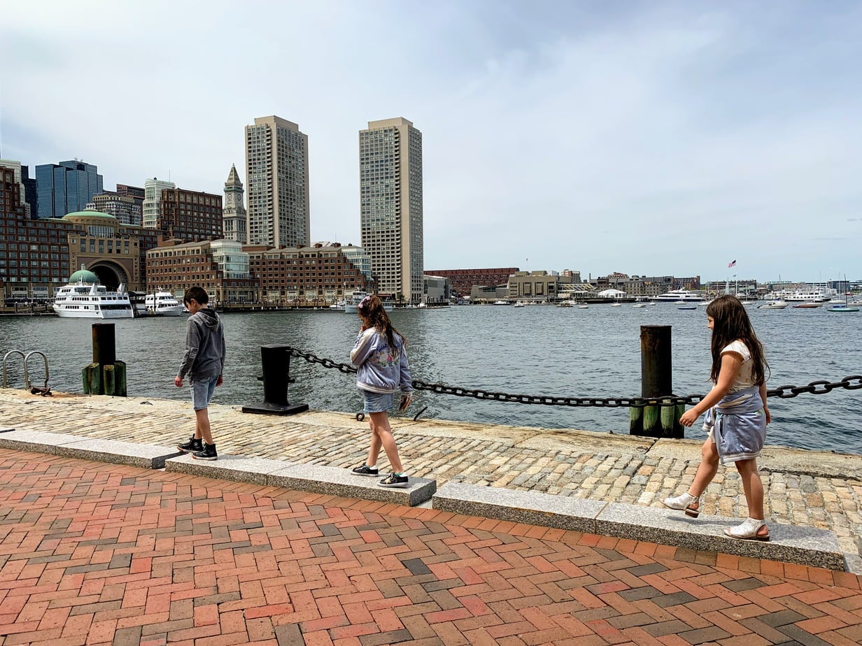 Children walking along Boston shore 
