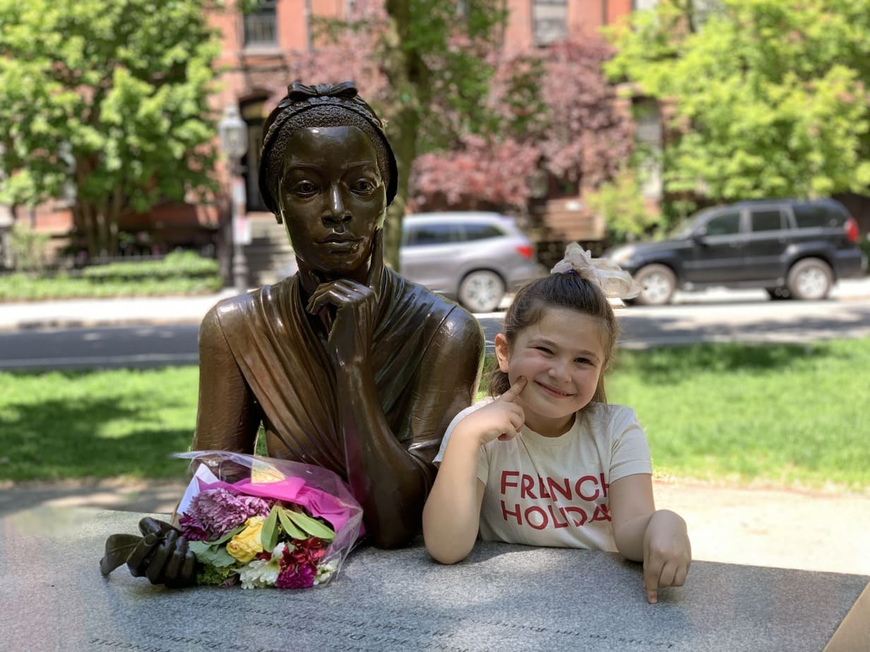 Child mimics statue at Boston Public Gardens
