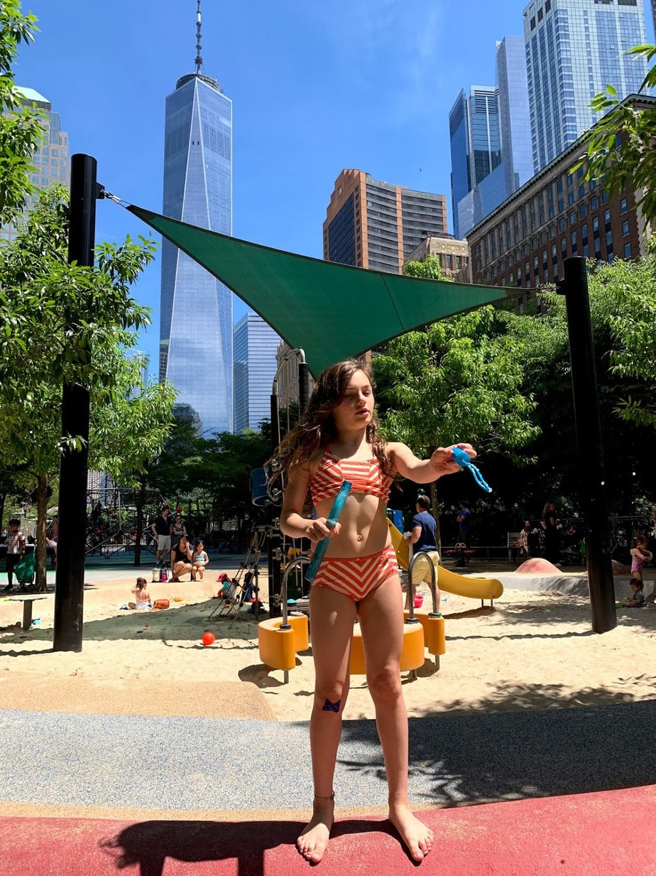 Girl playin in NYC wearing Tea Collection kid's swimwear