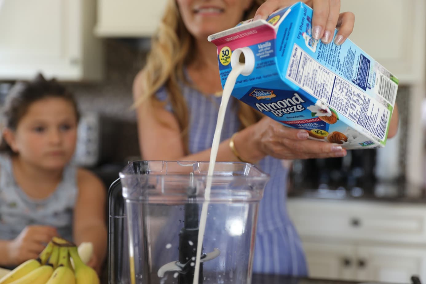 woman pouring best plant-based milk into blender