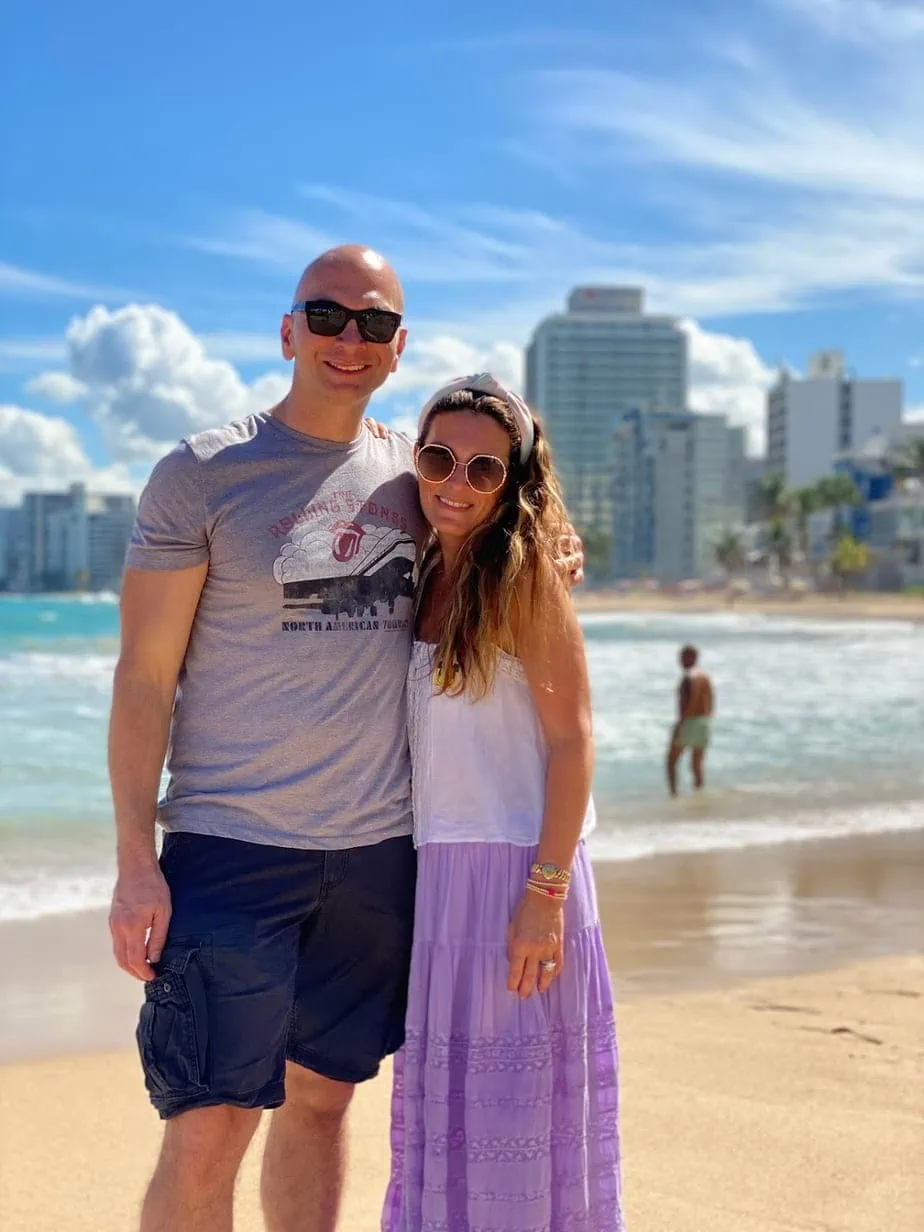 Couple stands on beach of San Juan, Puerto Rico in summer clothing
