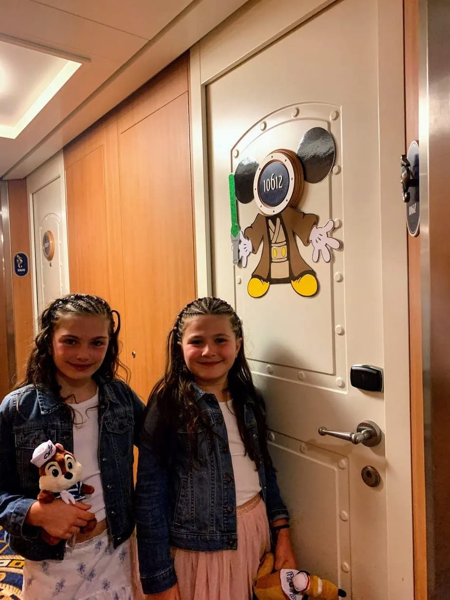 Girls standing in front of Disney Cruise suite doors  decorate with Mickey Mouse Star Wars 