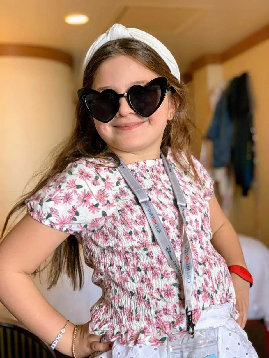 Daughter wearing perfect summer, vacation outfit: floral shirt, heart sunglasses, and a white headband