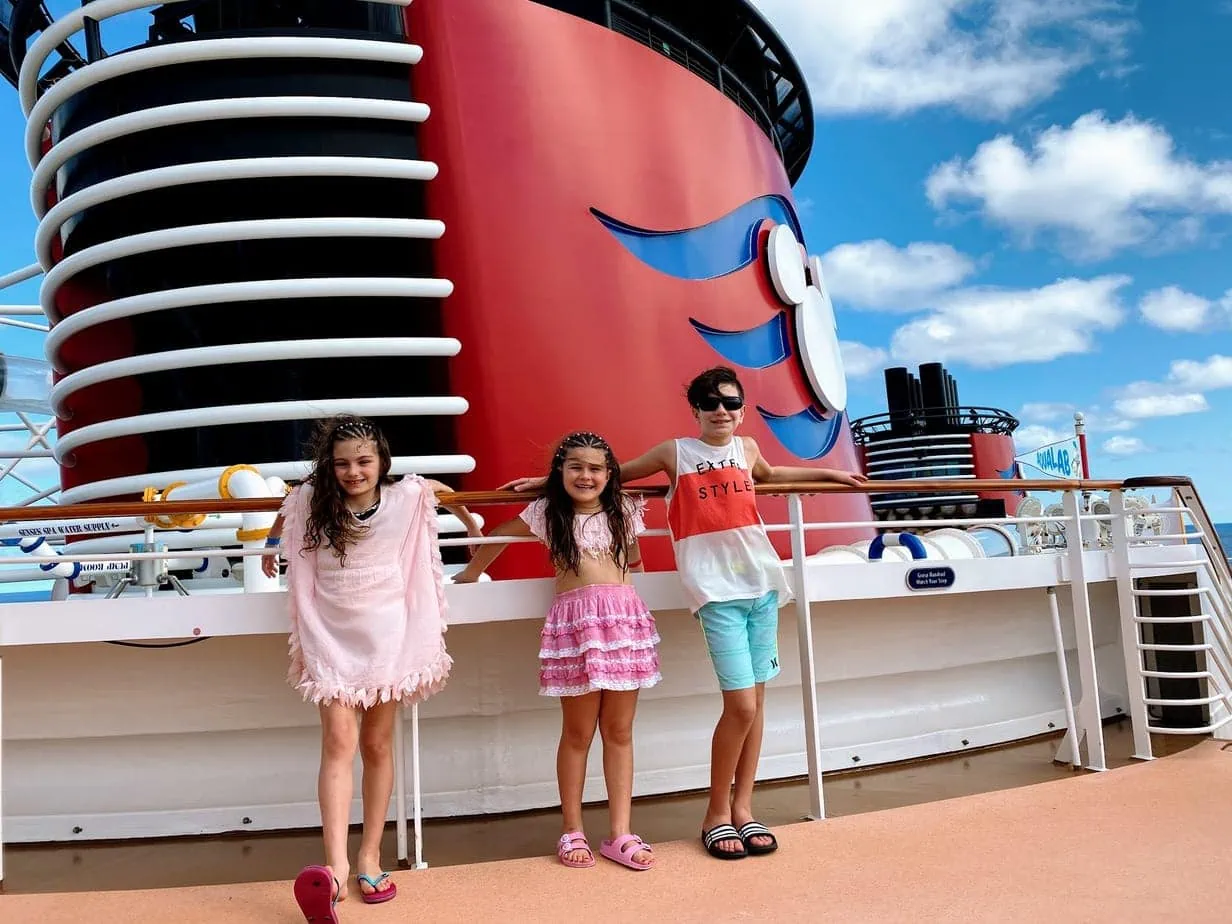 Kids hanging on railing of Disney cruise ship 