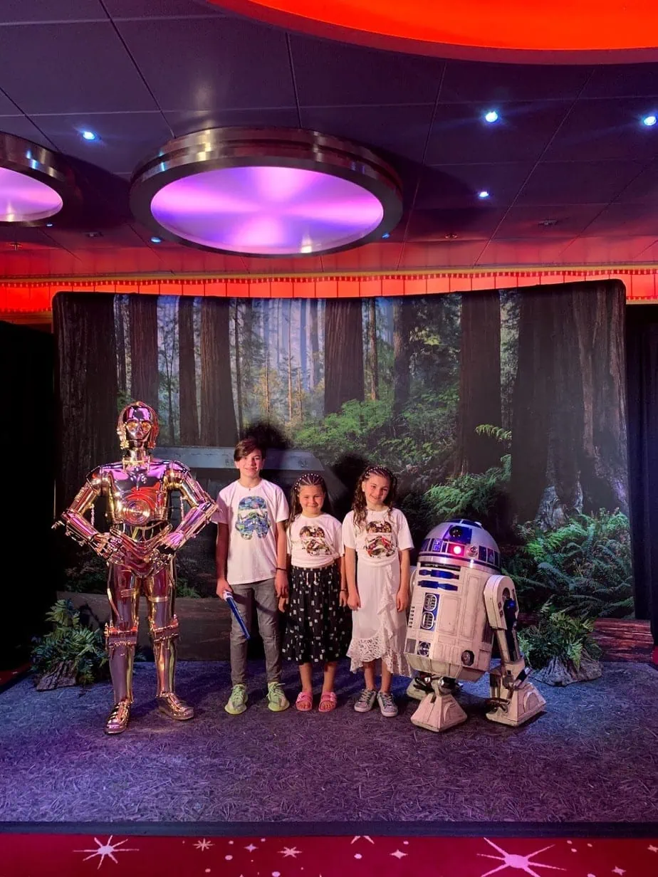 Kids posing with R2-D2 in front of forest background