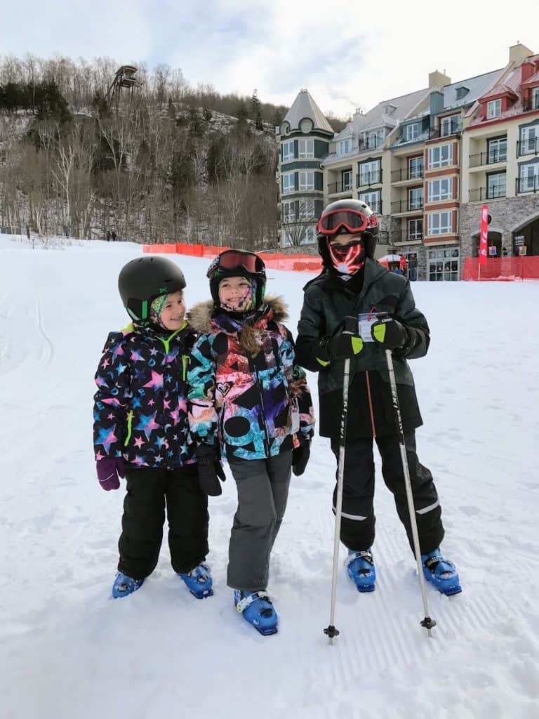Kids in ski gear on snowy mountain top