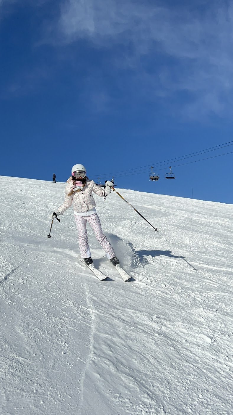 Brianne skiing down a French Alps mountain in fashionable, floral ski gear