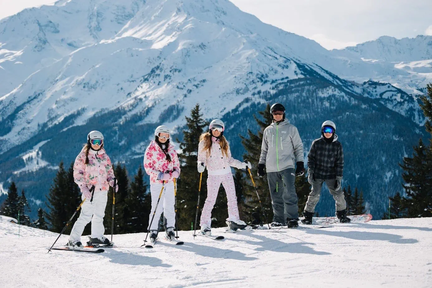 Family skiing in cute outfits with scenic mountain views
