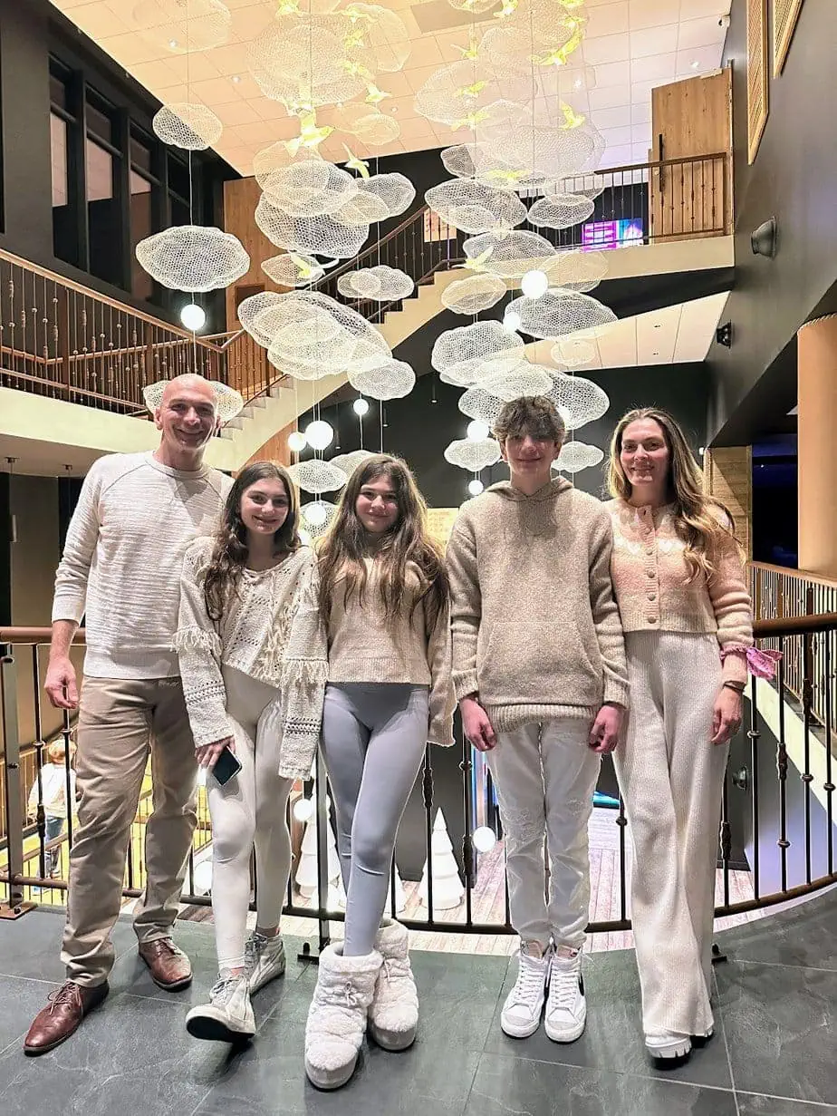 Family in all-cream outfits on a winter vacation in hotel lobby