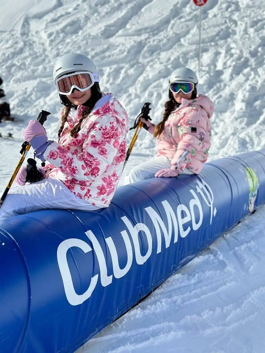 Daughters wearing pink ski gear while skiing in French Alps 