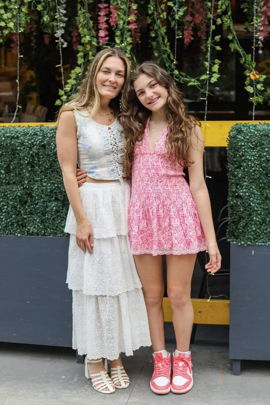 Brianne and her daughter wearing floral, Loveshackfancy outfits with plants in background 