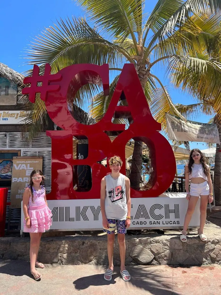 Kids posing in front of #Cabo sign of beach