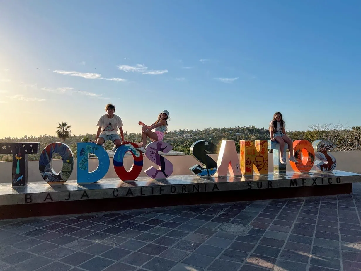 Kids posing with Todos Santos sign during sunset