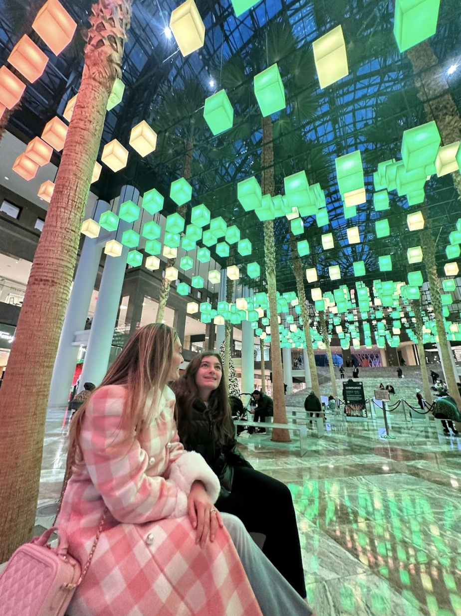 Brianne and her daughter wearing trending fall plaid pink jacket while looking up at holiday lights