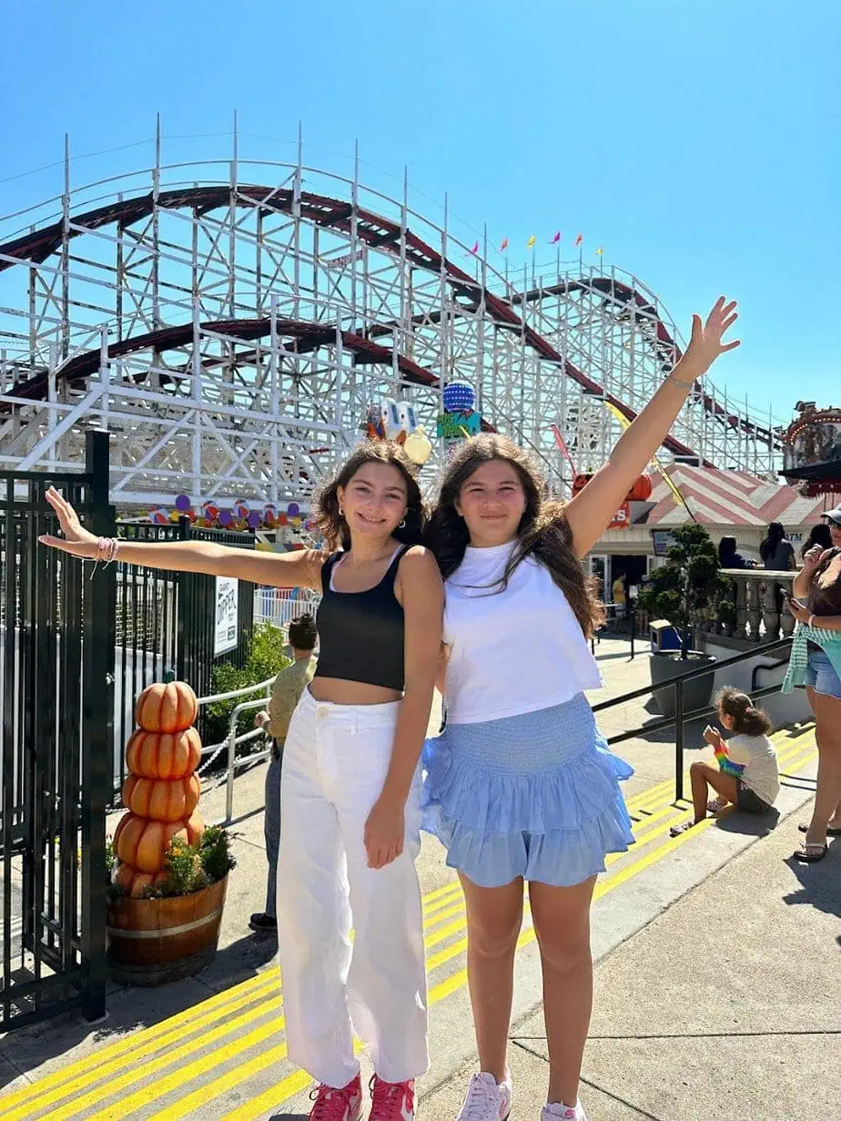 Daughters having fun with rollercoaster filled amusement Belmont Park in San Diego