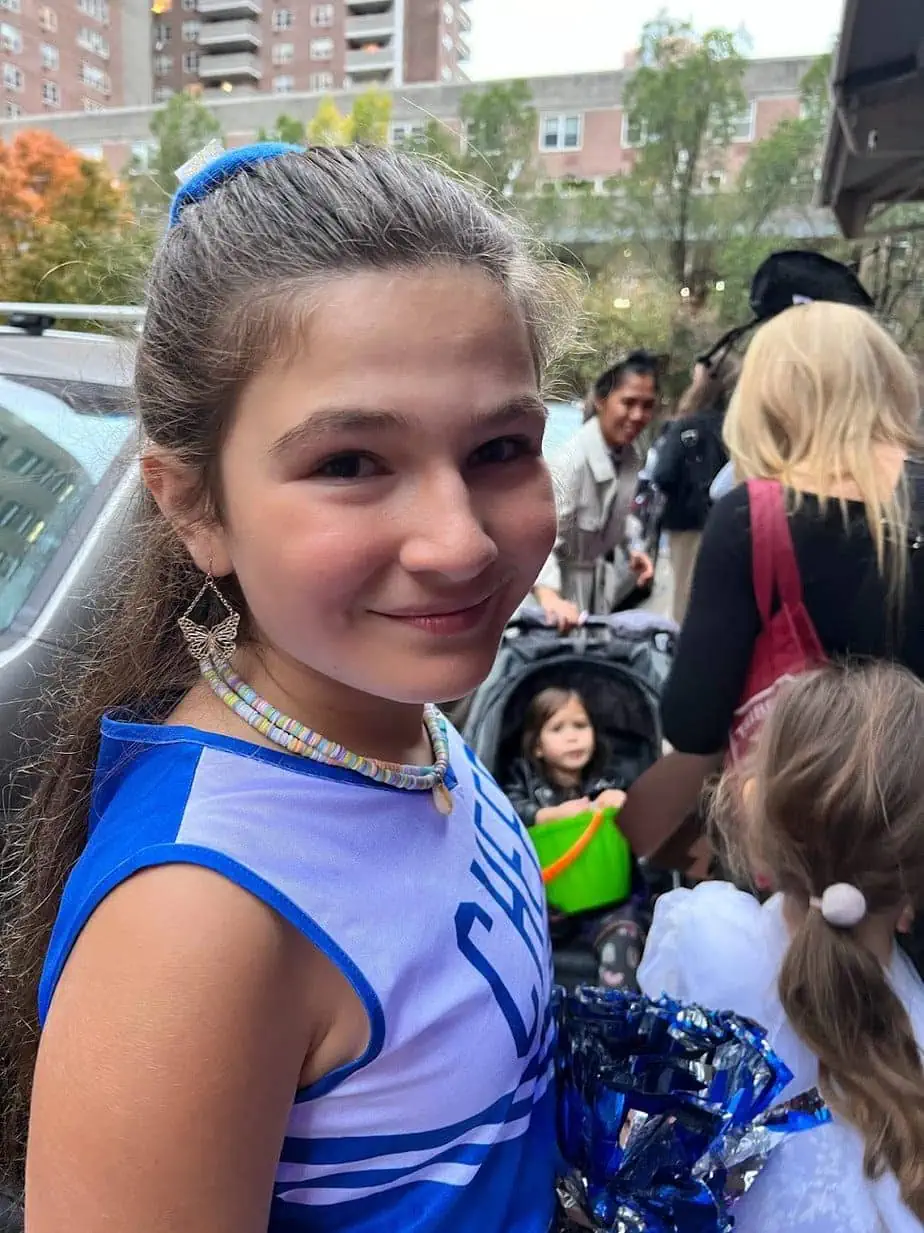 Daughter trick-or-treating in NYC with cheerleader costume