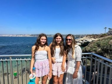 Mother and daughters enjoying beach view in San Diego